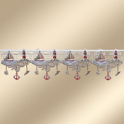 Eine dekorative Spitzenborte zeigt ein nautisches Thema mit gestickten Segelbooten, Leuchttürmen, Ankern und Muscheln in Weiß, Rot und Blau, die von einem netzartigen Untergrund vor einem beigen Hintergrund herabhängen.