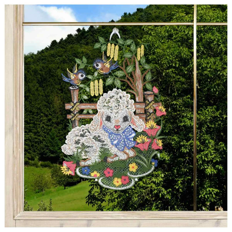 Verschönern Sie Ihr Zuhause mit dem "Fensterbild Schäfchen & Blaumeisen" (31x21 cm)! Diese exquisite vogtländische Spitze-Fensterdekoration in strahlendem Weiß und lebendigen Farben zeigt ein Lamm, Blaumeisen, Blumen und Gras - ein Muss für Ostern oder den Frühling.