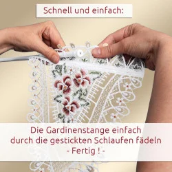 Hände fädeln eine Stange durch bestickte Schlaufen an einem Spitzenvorhang. Der deutsche Text lautet: „Schnell und einfach: Die Gardinenstange einfach durch die gestickten Schlaufen Fädeln – Fertig!“