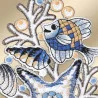 Detaillierte Stickereien zeigen einen Patchwork-Fisch, eine gestreifte Muschel und einen Seestern aus blauem, goldenem, weißem und schwarzem Garn – klassische Vogtländische Spitze – vor einem hellbeigen Hintergrund mit stilisierten Korallen- und maritimen Fensterbilder-Akzenten.