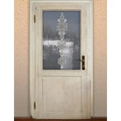 Eine Holztür mit einem Milchglasfenster, auf dem ein vertikales Fensterbild aus weißen Schneeflocken zu sehen ist; durch das Glas ist eine verschneite Außenlandschaft zu sehen.