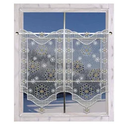 Ein Fenster mit durchsichtigen Spitzenvorhängen mit einem komplizierten Schneeflockenmuster, eingerahmt von hellem Holz. Der Blick nach draußen zeigt einen klaren blauen Himmel.