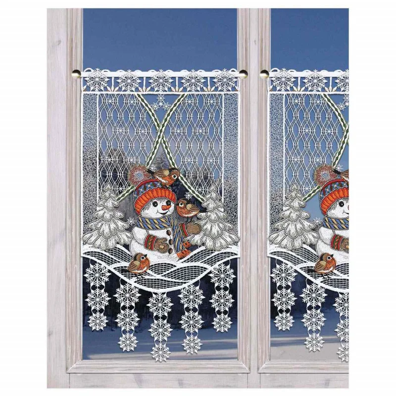 Dekorativer Spitzenvorhang mit einer Winterszene, die einen Schneemann mit Mütze und Schal, Vögel, Bäume und Schneeflocken zeigt und an einem Fenster mit verschneitem Außenhintergrund angebracht ist.