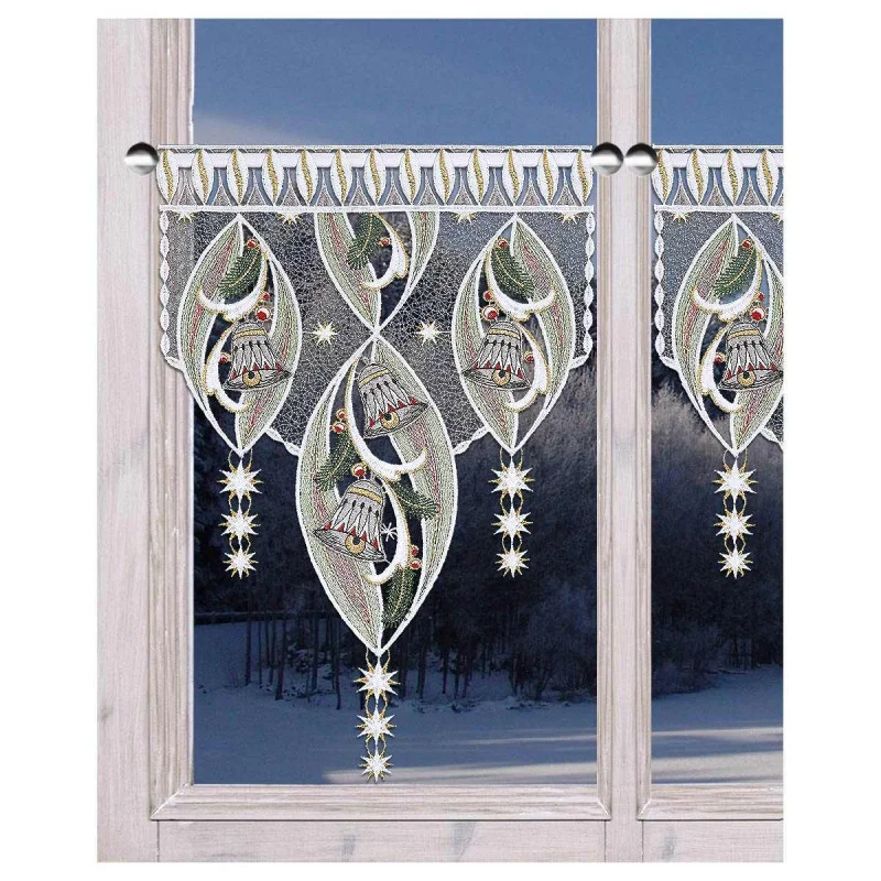 Spitzenvorhänge mit verschlungenen Glocken- und Sternmustern hängen an einem Fenster, aus dem eine verschneite Winterlandschaft zu sehen ist.