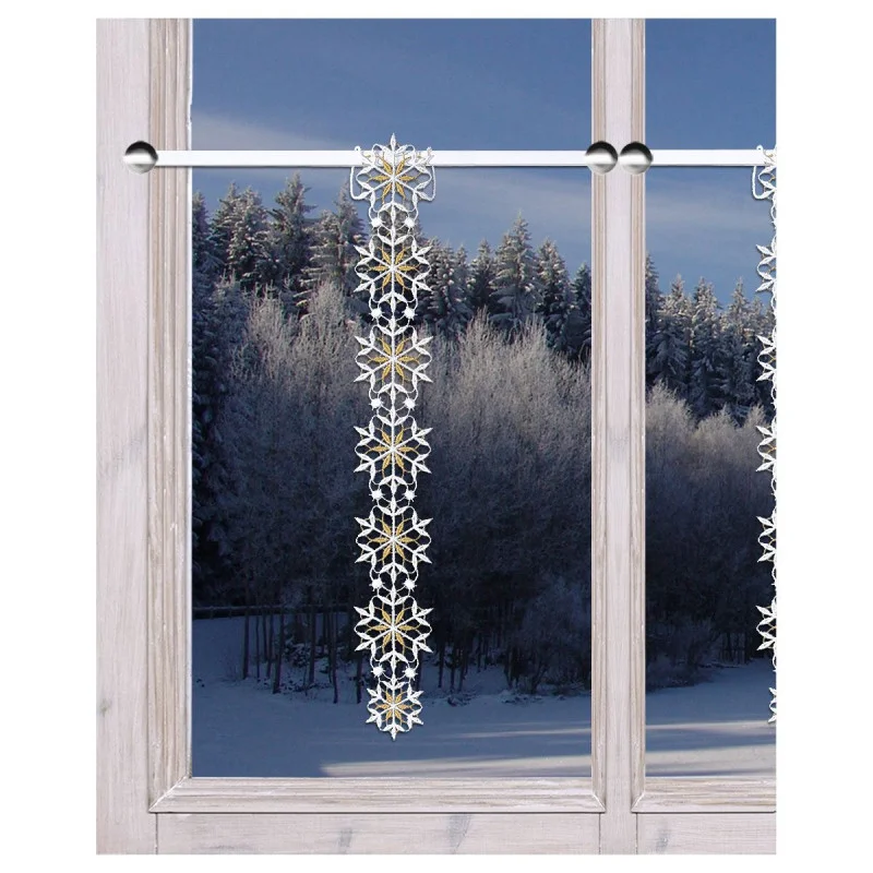 Eine frostige Winterszene vor einem Fenster mit schneebedeckten Bäumen; eine dekorative vertikale Girlande mit Schneeflockenornamenten hängt von einer Gardinenstange über dem Fenster.