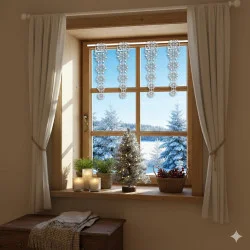 Ein gemütliches Fenster mit weißen Vorhängen bietet einen Blick auf eine verschneite Landschaft mit Tannenbäumen. Auf der Fensterbank stehen Kerzen, ein kleiner Weihnachtsbaum und ein Korb mit Tannenzapfen; am Fensterrahmen hängt Schneeflockenschmuck.