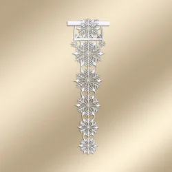 Eine zarte Girlande aus weißer Spitze mit einem verschlungenen Muster aus miteinander verbundenen Schneeflocken, die vertikal vor einem zartbeigen Hintergrund hängen.