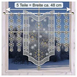 Spitzenvorhänge mit Schneeflocken hängen an einem Fenster und geben den Blick auf eine verschneite Landschaft frei.