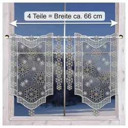 Spitzenvorhänge mit Schneeflocken hängen an einem Fenster und geben den Blick auf eine verschneite Landschaft frei.