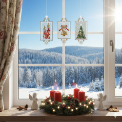 Durch ein mit festlichen Fensterbildern Adventszeit und Kreuzstich-Ornamenten geschmücktes Fenster blickt man in einen verschneiten Wald. Auf der Fensterbank steht ein Kerzenkranz mit vier roten Kerzen, zwei Engelsfiguren, Tannenzapfen und einer warmen Lichterkette.