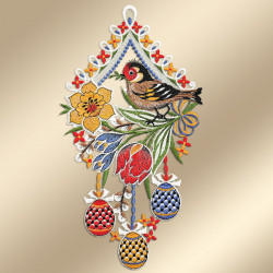 Der dekorative Wandbehang zeigt einen bunten Vogel, der auf grünen Blättern sitzt und von gelben und roten Blumen umgeben ist. Unter dem Vogel hängen drei gemusterte Ostereier in Rot, Blau und Gelb über einer verzierten beigen Bordüre mit weißen, blauen und roten Details.
