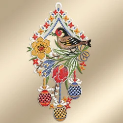 Der dekorative Wandbehang zeigt einen bunten Vogel, der auf grünen Blättern sitzt und von gelben und roten Blumen umgeben ist. Unter dem Vogel hängen drei gemusterte Ostereier in Rot, Blau und Gelb über einer verzierten beigen Bordüre mit weißen, blauen und roten Details.