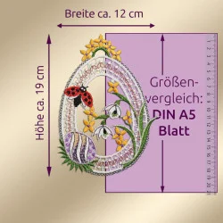 Eine eiförmige Stickerei, die einen Marienkäfer, gelbe Blumen und weiße Schneeglöckchen zeigt, ist neben einem lila A5-Blatt abgebildet, um den Maßstab zu verdeutlichen. Die Stickerei misst etwa 19 cm in der Höhe und 12 cm in der Breite.