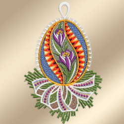 Ein gesticktes Osterei mit violetten Blüten mit gelber Mitte, grünen Blättern und bunten Mustern in Blau, Orange und Rot. Eine weiße Spitzenbordüre und grüne tannenähnliche Zweige mit einer Schleife betonen das Design. Der Hintergrund ist hellbeige.