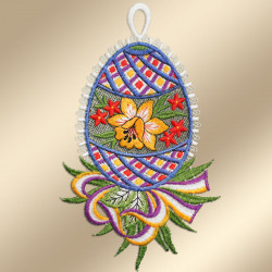 Ein gesticktes eiförmiges Ornament mit einer gelben Lilie, roten Sternen und grünen Blättern in der Mitte, umgeben von blauen, lila und roten geometrischen Mustern. Darunter erstreckt sich ein dekoratives, mehrfarbiges Blumenmotiv, und oben befindet sich eine weiße Schlaufe zum Aufhängen.