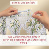 Zwei Hände führen eine weiße Stange durch gestickte Schlaufen am oberen Ende eines mit Blumenmustern verzierten Spitzenvorhangs. Der deutsche Text oben und unten gibt Anweisungen zum Aufhängen des Vorhangs, indem die Stange durch die genähten Schlaufen geschoben wird.