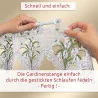 Zwei Hände führen eine weiße Stange durch gestickte Schlaufen am oberen Ende eines mit Blumenmustern verzierten Spitzenvorhangs. Der deutsche Text oben und unten gibt Anweisungen zum Aufhängen des Vorhangs, indem die Stange durch die genähten Schlaufen geschoben wird.