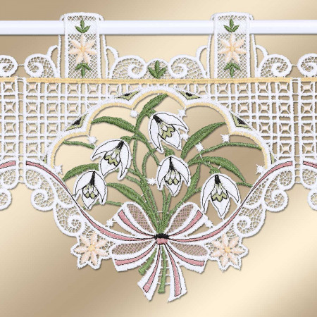 Vorhangstoff aus Spitze mit gestickten weißen Schneeglöckchen mit grünen Stielen. Der Strauß ist von komplizierten Spitzenmustern umgeben und mit einer rosa gestreiften Schleife und kleinen gelben Blumen akzentuiert. Der Vorhang wird an einer Stange mit Schlaufen aufgehängt.