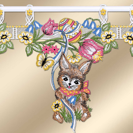 Gesticktes Vorhangpaneel mit einem braunen Hasen mit großen Ohren, der einen roten Schal trägt und pastellfarbene Ostereier in der Hand hält, umgeben von rosa Blumen, gelben Gänseblümchen, grünen Blättern und einem Schmetterling. Das Paneel hängt an weißer Spitze auf einem goldenen Hintergrund.