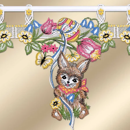 Gesticktes Vorhangpaneel mit einem braunen Hasen mit großen Ohren, der einen roten Schal trägt und pastellfarbene Ostereier in der Hand hält, umgeben von rosa Blumen, gelben Gänseblümchen, grünen Blättern und einem Schmetterling. Das Paneel hängt an weißer Spitze auf einem goldenen Hintergrund.