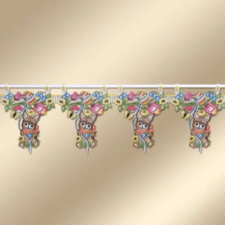 Bestickter Spitzenvolant mit vier detaillierten Hasenmotiven, die jeweils zwischen mehrfarbigen Blumen und Blättern angeordnet sind. Der Volant ist an einer weißen Stange vor einem beigen Hintergrund aufgehängt und dient als dekorative Fensterverkleidung.