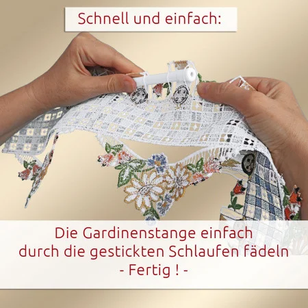 Zwei Hände fädeln einen weißen Stab durch die genähten Schlaufen am oberen Ende eines dekorativen Spitzenvorhangs mit floralem Muster. Der Hintergrund ist einfarbig. Ein deutscher Anleitungstext zeigt, wie man die Stange durch die Schlaufen führt, um die Gardine aufzuhängen.