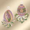 Zwei gestickte Eier mit detaillierten Mustern und floralen Motiven in Rosa, Lila, Grün und Gelb sind auf einem Hintergrund mit sanftem Beige-Farbverlauf angeordnet. Jedes Ei steht auf einem dekorativen Blattsockel und ist mit einer Schlaufe zum Aufhängen versehen.