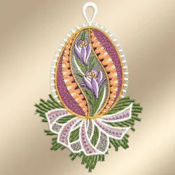Ein kunstvoll gesticktes eiförmiges Ornament mit violetten Krokusblüten und grünen Blättern, umrandet von orangen, gelben und violetten Mustern. Das Ei ruht auf grünem Gras mit einer weißen Schleife am unteren Ende und einer weißen Schlaufe am oberen Ende zum Aufhängen.