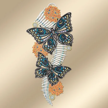 Zwei schwarz und blau gestickte Schmetterlinge ruhen auf einer geschwungenen, weißen, rippenartigen Struktur. Orangefarbene und gelbe kreisförmige Spitzenmuster umgeben die Schmetterlinge. Der Hintergrund ist in einem sanften Beigeton gehalten.