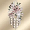 Gesticktes Motiv mit zwei rosafarbenen Lilien mit grünen Blättern, die mit weißen Spitzenmustern und einem rautenförmigen Netzsaum am unteren Rand verziert sind. Die Stickerei ist auf einem weichen beigen Hintergrund zu sehen.