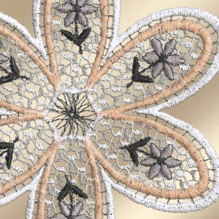 Nahaufnahme einer gestickten Blume mit fünf Blütenblättern. Die Blütenblätter sind mit weißem, beigem und schwarzem Garn in detaillierten Spitzenmustern gestickt, wobei jedes ein kleineres Blumenmotiv in der Mitte aufweist. Der Hintergrund ist in einem sanften Beigeton gehalten.