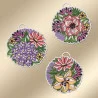 Drei kreisförmig gestickte Ornamente mit weißen Rändern sind auf einem beigen Hintergrund angeordnet. Das linke Ornament zeigt violette und rote Blumen, das obere rechts zeigt rosa und violette Blumen und das untere rechts zeigt gelbe, violette und orange Blumen.