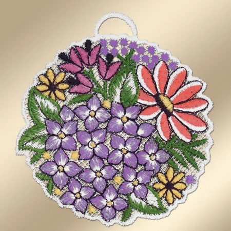 Ein kreisförmiges gesticktes Abzeichen zeigt violette, rote und gelbe Blumen mit grünen Blättern, die alle mit weißen Nähten eingefasst sind. Der Hintergrund ist hellgoldfarben. An der Oberseite des Aufnähers ist eine kleine Stoffschlaufe angebracht, die das Aufhängen erleichtert.