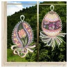 Das Fensterbilder 2er Set Ostereier mit Tulpe und Veilchen Plauener Spitze rosa zeigt zwei dekorative eiförmige Spitzen-Fensterbehänge; der eine zeigt eine rosafarbene Tulpe, der andere violette Veilchen, beide verziert mit Bändern und aufwändigen Spitzendetails.
