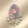 Ein gesticktes Ornament in Form eines Eies zeigt in der Mitte eine rosa Tulpe mit grünen Blättern. Der Hintergrund ist mit gelben und violetten Blumenmustern versehen und der Rand ist mit weißer Spitze eingefasst. Ein mehrfarbiges Band und Grünzeug akzentuieren den Sockel.