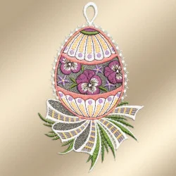 Ein gesticktes Ornament in Form eines Eies mit violetten und weißen Blüten und grünen Blättern in der Mitte, akzentuiert durch rosa, gelbe und orangefarbene Muster. An der Basis befindet sich eine weiß-gold-grüne Zierschleife, oben ist eine Schlaufe zum Aufhängen angebracht.