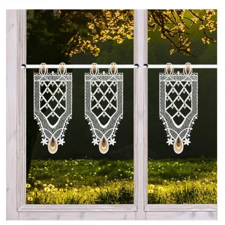 Zwei holzgerahmte Fensterscheiben mit durchsichtigen, kunstvoll gemusterten Spitzenvorhängen, die an Stangen hängen. Außerhalb der Fenster fällt das Sonnenlicht durch blühende Baumzweige auf eine Wiese mit gelben Wildblumen.