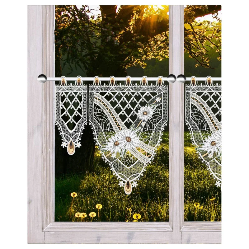 Das Sonnenlicht fällt durch ein Fenster mit Spitzenvorhängen, die mit floralen Mustern und Tropfenformen verziert sind. Draußen sieht man eine Wiese mit gelben Blumen und die Silhouetten von Bäumen unter einem strahlend goldenen Himmel bei Sonnenaufgang oder Sonnenuntergang.