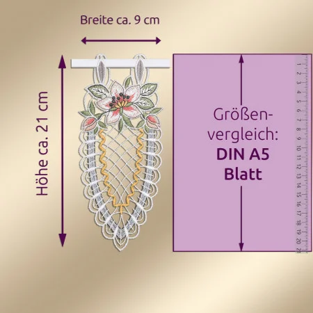Ein Spitzenornament mit Blumenstickerei hängt an einem weißen Stab. Das Muster besteht aus rosa und weißen Blüten, grünen Blättern und goldenen Verzierungen. Die Maße sind mit ca. 21 cm in der Höhe und 9 cm in der Breite angegeben. Auf der rechten Seite sind ein Lineal und eine DIN A5-Größenangabe zu sehen.