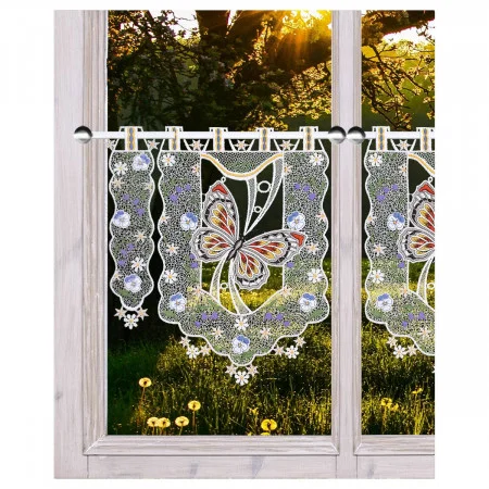 Spitzenvorhänge mit Schmetterlings- und Blumenmustern sind an einem Holzfenster aufgehängt. Das Sonnenlicht fällt durch die Bäume draußen und beleuchtet das grüne Gras und die gelben Blumen auf der anderen Seite des Fensters.