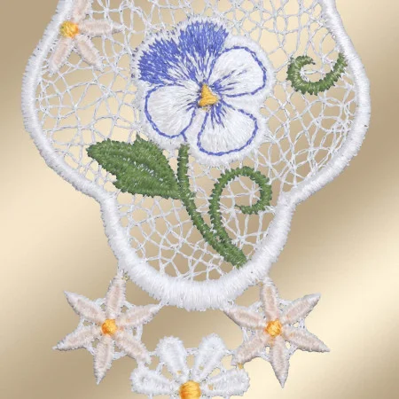Spitzenstickerei mit einem violett-weißen Stiefmütterchen mit grünen Blättern in der Mitte, eingerahmt von detaillierten weißen Spitzenmustern. Darunter befinden sich drei cremefarbene sternförmige Blumen mit gelben Zentren und eine kleine weiße Blume, alles auf einem goldenen Hintergrund.