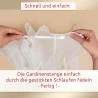 Das Bild zeigt zwei Hände, die eine weiße Gardinenstange durch Schlaufen führen, die am oberen Rand eines weißen, durchsichtigen Vorhangs eingenäht sind. Der Hintergrund ist beige. Oberhalb und unterhalb des Bildes ist ein deutscher Text zu sehen, der Anweisungen zum Vorgehen enthält.