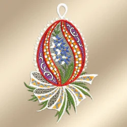 Eine verschnörkelte, eiförmige Stickerei mit rotem und orangefarbenem Rand, weißen und blauen Blumen in der Mitte und grünen Blättern darunter. Das Muster ist mit verschlungenen Mustern verziert und von einer weißen, spitzenartigen Umrandung auf hellbeigem Hintergrund umgeben.